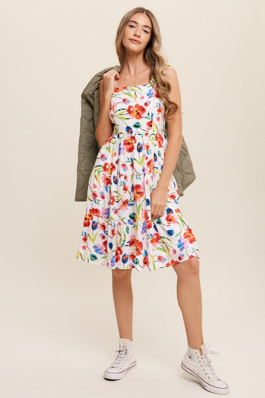 A woman can be seen twirling in the Flower Print Square Neck Dress, which features ruffle shoulder straps, while maintaining a neutral expression against a plain background.