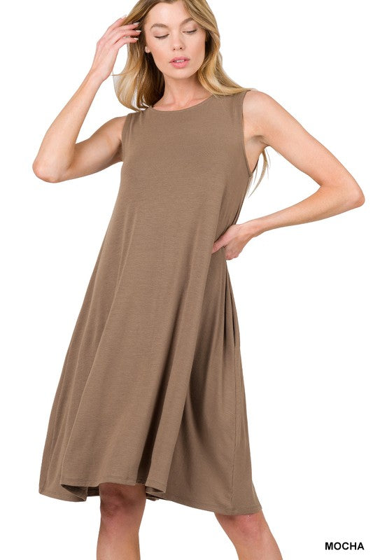 A woman posing in a casual mocha-colored Sleeveless Flared Dress with Side Pockets, standing with one hand on her head.
