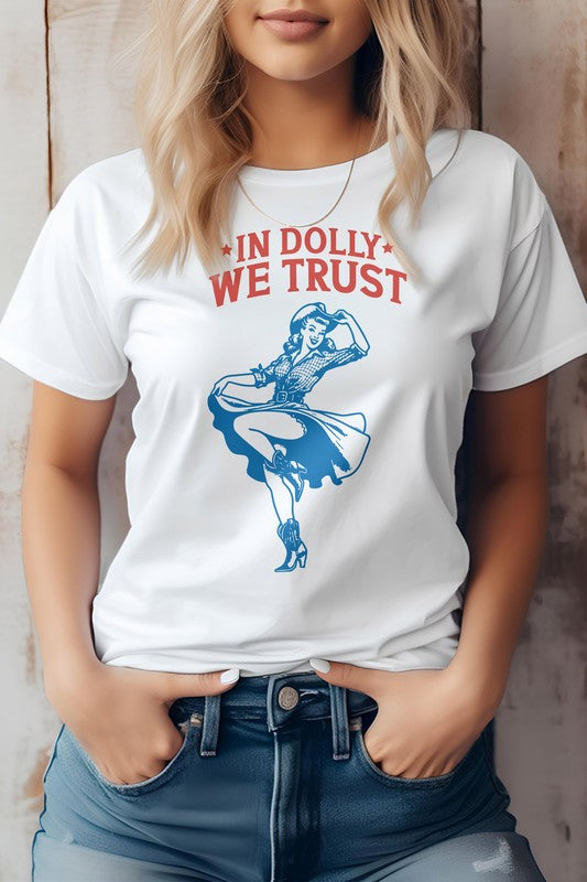 A person wearing the "In Dolly We Trust, Retro Western Graphic Tee" made from eco-friendly materials, showcasing a dancing woman graphic with the text "IN DOLLY WE TRUST" in red on a white T-shirt.