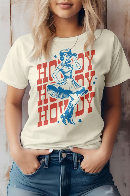 Woman wearing a light gray "Howdy Howdy Howdy, Retro Western Graphic Tee" featuring a cowgirl illustration, paired with denim shorts.