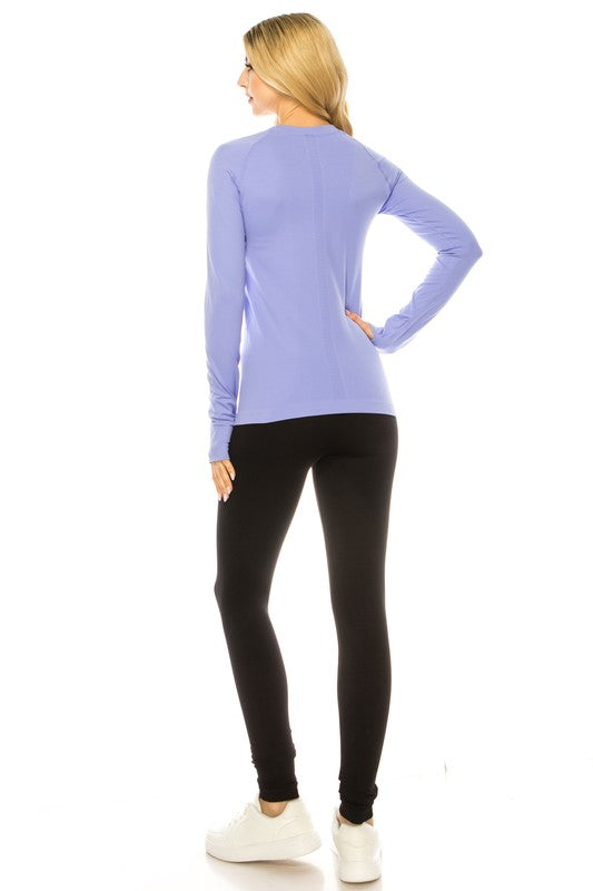 A person is standing in a bright yellow Long Sleeve Workout Shirt for Women, paired with black leggings and white sneakers, posing against a white background. This outfit perfectly showcases stylish athletic wear.