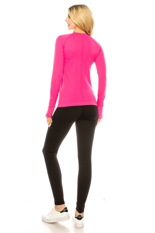 A person is standing in a bright yellow Long Sleeve Workout Shirt for Women, paired with black leggings and white sneakers, posing against a white background. This outfit perfectly showcases stylish athletic wear.