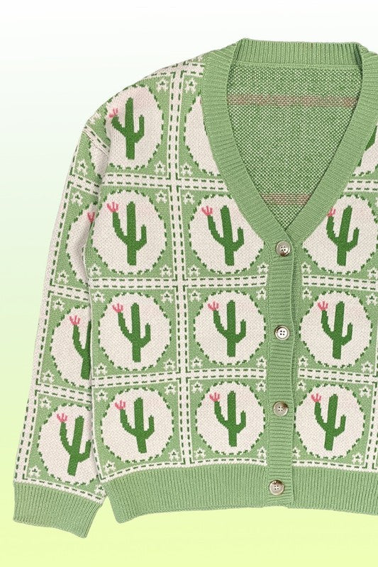 The PLUS SIZE Cactus Tiled Knit Cardigan features a V-neck, full-length sleeves, and a button-down front, adorned with a white and green cactus intarsia pattern. Perfectly tailored for plus sizing.