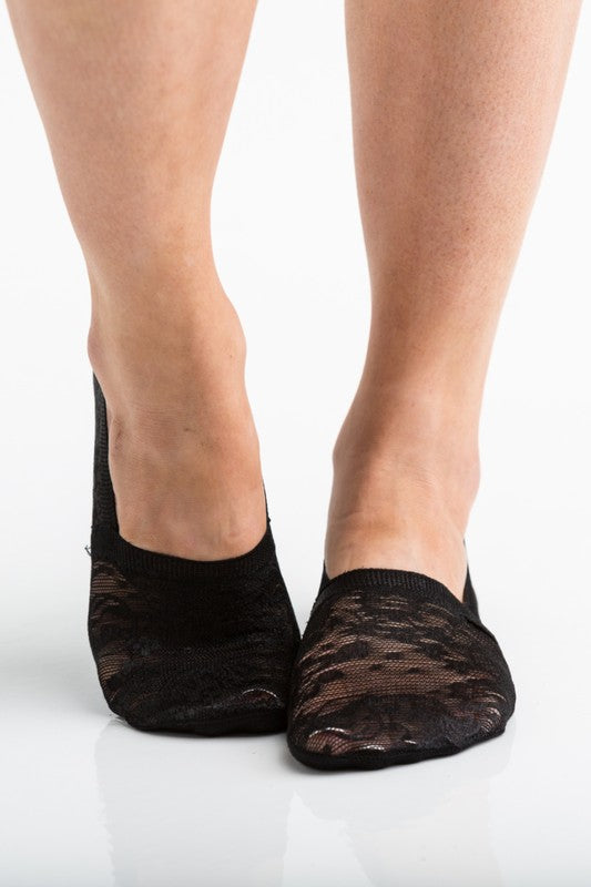 Wearing a pair from the No Slip Floral Lace Sneaker Socks- 3 Pack, her feet are stylishly clad in nude-colored no-show socks featuring a delicate floral lace pattern. A small ankle tattoo with three dots adds a personal touch, while the no-slip design ensures they stay perfectly in place.