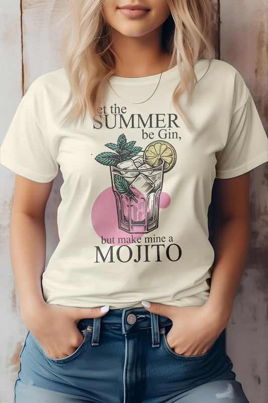 Person wearing a Vintage Summer Beach light green graphic tee featuring a party cocktail with mint leaves and a lime slice, along with the text "Let the summer be gin, but make mine a mojito." The unisex fit ensures it's perfect for anyone looking to celebrate in style.