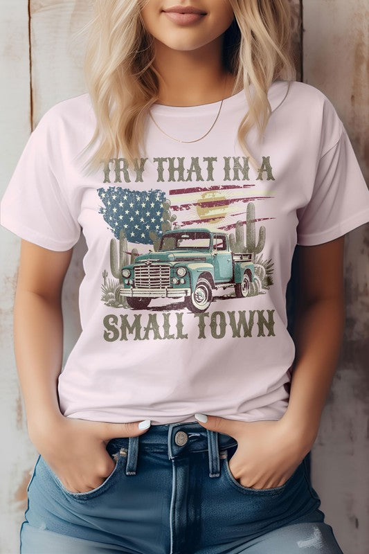 A person is wearing the "Try That in a Small Town Western Graphic Tee," showcasing an old truck, cacti, and an American flag, making it an ideal tribute for those who appreciate cowboy culture and country music.