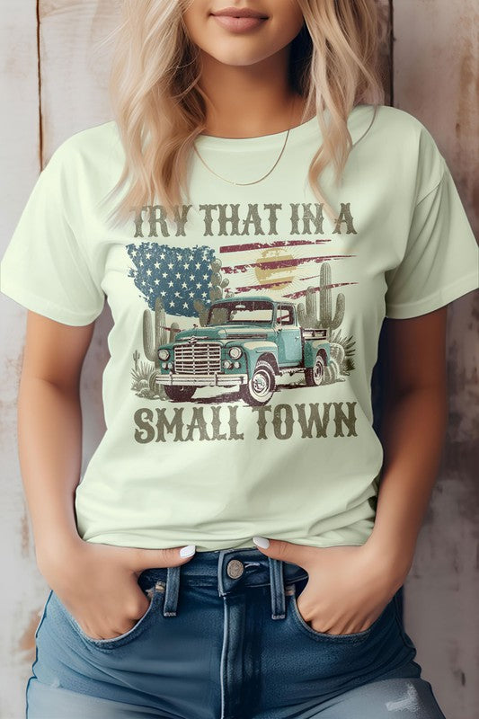 A person is wearing the "Try That in a Small Town Western Graphic Tee," showcasing an old truck, cacti, and an American flag, making it an ideal tribute for those who appreciate cowboy culture and country music.