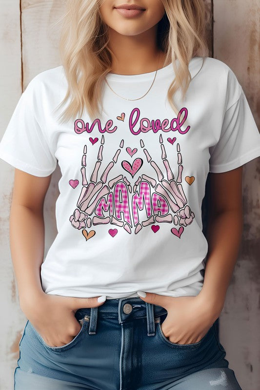 Woman wearing the "One Loved Mama" Mother's Day graphic tee, an eco-friendly pink shirt featuring decorative text and skeleton hand illustrations.