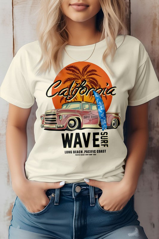 A person wearing a California Wave Surf Vintage Graphic Tee featuring an eco-friendly design with a vintage car, palm trees, and the text "Wave Surf Long Beach - Pacific Coast" is depicted.