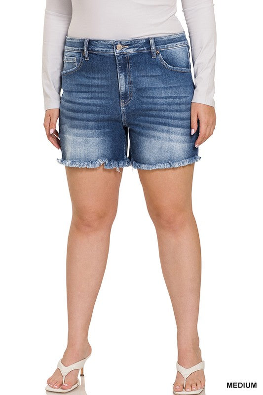 A person is wearing Zenana's Plus Mid Rise Raw Frayed Hem Denim Shorts in blue.