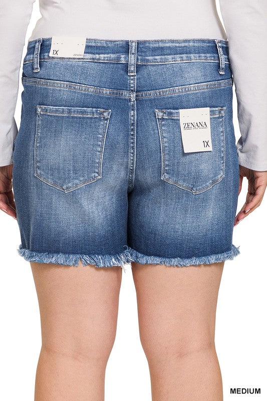 A person is wearing Zenana's Plus Mid Rise Raw Frayed Hem Denim Shorts in blue.