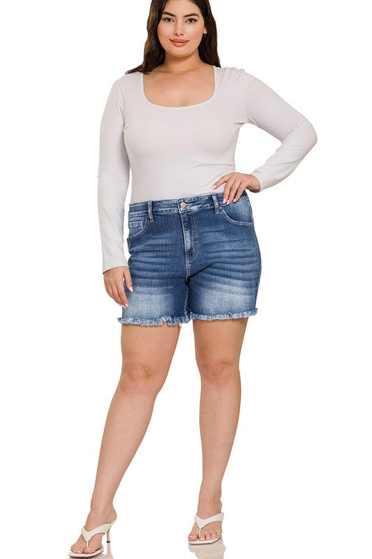 A person is wearing Zenana's Plus Mid Rise Raw Frayed Hem Denim Shorts in blue.