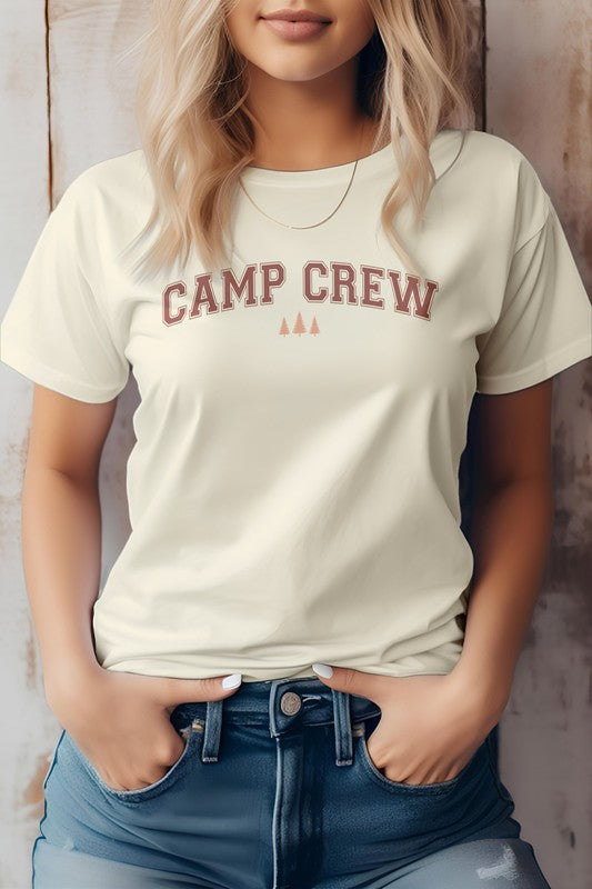 A person in a "Camping Outdoor Mountain Graphic Tee" and jeans stands against a rustic wooden background, embodying the spirit of camping.