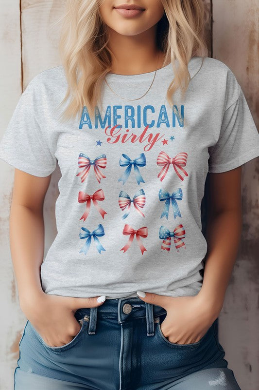 A person sporting the Patriotic Coquette Bow 4th of July Graphic Tee, featuring nine red, white, and blue bows, is proudly embracing the American flag vibe for Independence Day celebrations.