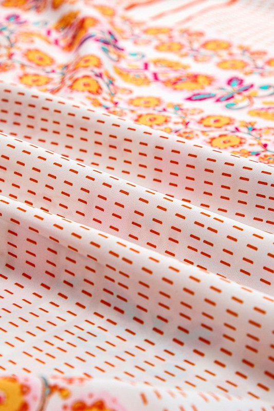 A Patchwork mint coral long sundress, featuring a Bohemian-inspired colorful patchwork print, sleeveless design with spaghetti straps and a square neckline, along with an A-line silhouette, is hanging on a wooden hanger against a plain white background.