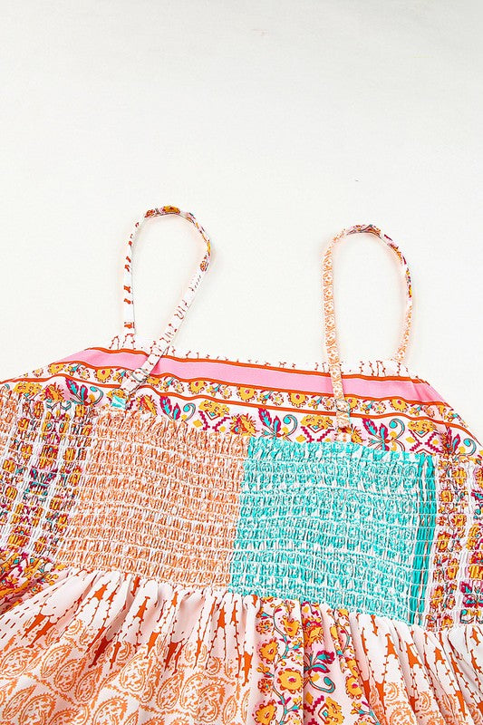 A Patchwork mint coral long sundress, featuring a Bohemian-inspired colorful patchwork print, sleeveless design with spaghetti straps and a square neckline, along with an A-line silhouette, is hanging on a wooden hanger against a plain white background.