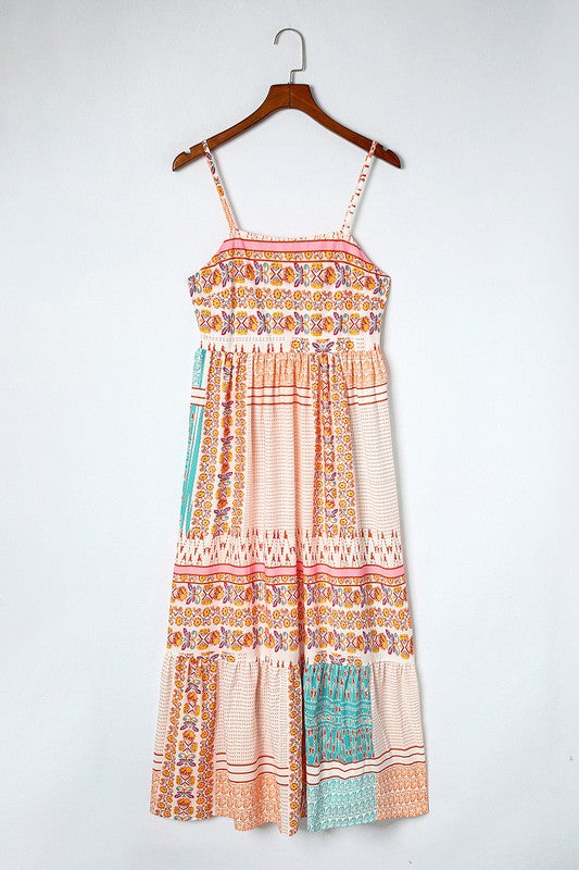 A Patchwork mint coral long sundress, featuring a Bohemian-inspired colorful patchwork print, sleeveless design with spaghetti straps and a square neckline, along with an A-line silhouette, is hanging on a wooden hanger against a plain white background.