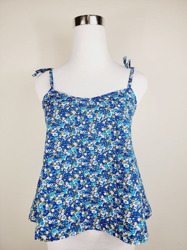 The Cotton Tank Top, a premium quality Boho tank top with adjustable straps, is displayed on a mannequin against a plain background. The sleeveless blue floral design adds an elegant touch to the garment.