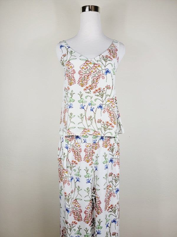 A Cotton Tank Top with adjustable straps, featuring a sleeveless, V-neck design made from Turkish cotton and adorned with a floral print of pink and blue flowers on a mannequin.