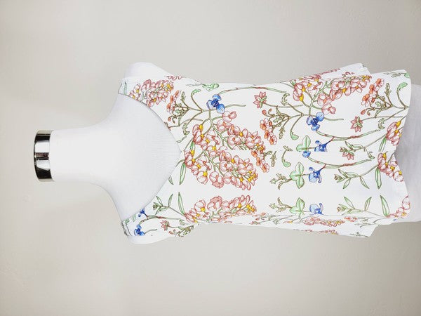 A Cotton Tank Top with adjustable straps, featuring a sleeveless, V-neck design made from Turkish cotton and adorned with a floral print of pink and blue flowers on a mannequin.