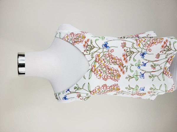 A Cotton Tank Top with adjustable straps, featuring a sleeveless, V-neck design made from Turkish cotton and adorned with a floral print of pink and blue flowers on a mannequin.