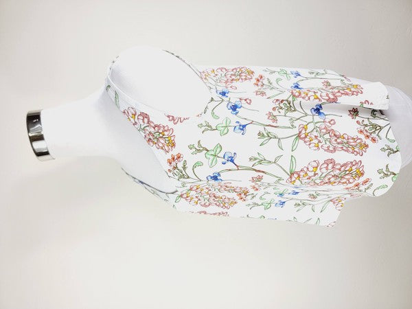 A Cotton Tank Top with adjustable straps, featuring a sleeveless, V-neck design made from Turkish cotton and adorned with a floral print of pink and blue flowers on a mannequin.