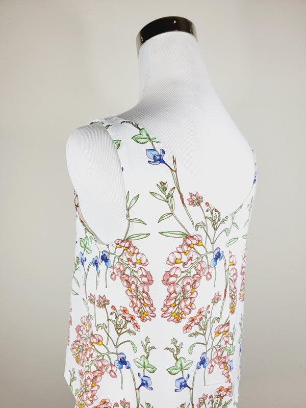 A Cotton Tank Top with adjustable straps, featuring a sleeveless, V-neck design made from Turkish cotton and adorned with a floral print of pink and blue flowers on a mannequin.