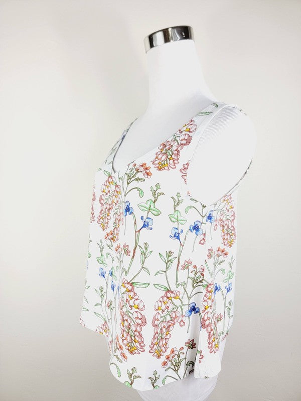 A Cotton Tank Top with adjustable straps, featuring a sleeveless, V-neck design made from Turkish cotton and adorned with a floral print of pink and blue flowers on a mannequin.