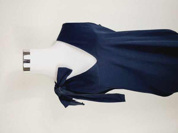 A mannequin displays a Cotton Jersey dress in navy blue with side pockets, featuring a sleeveless design and a large bow on the left shoulder.