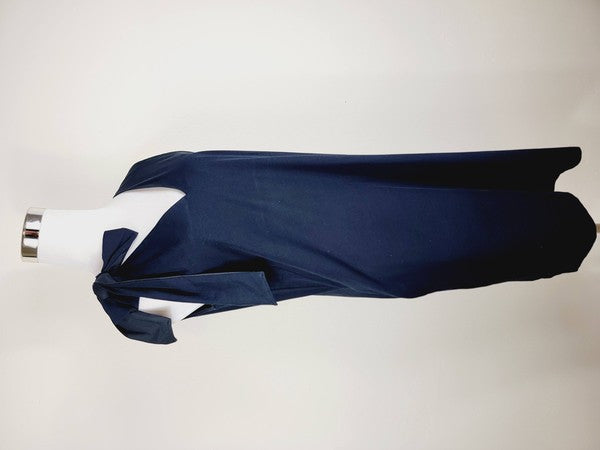 A mannequin displays a Cotton Jersey dress in navy blue with side pockets, featuring a sleeveless design and a large bow on the left shoulder.