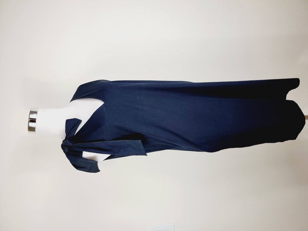 A mannequin displays a Cotton Jersey dress in navy blue with side pockets, featuring a sleeveless design and a large bow on the left shoulder.