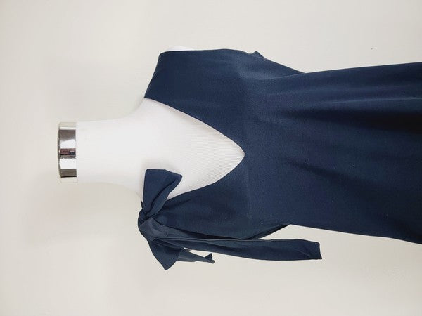 A mannequin displays a Cotton Jersey dress in navy blue with side pockets, featuring a sleeveless design and a large bow on the left shoulder.