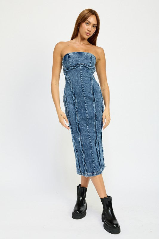 A person wearing the TUBE FRAYED SEAM MIDI DRESS, a strapless, form-fitting denim dress with frayed edges, and imported black ankle boots poses against a plain white background.