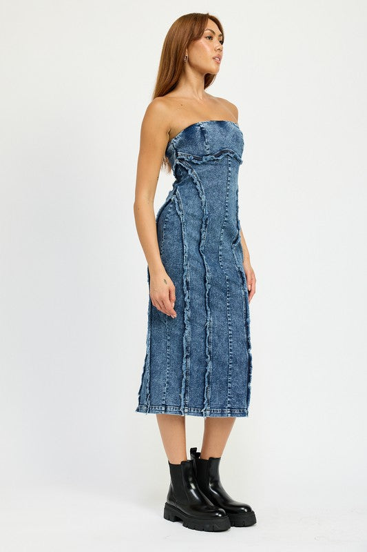 A person wearing the TUBE FRAYED SEAM MIDI DRESS, a strapless, form-fitting denim dress with frayed edges, and imported black ankle boots poses against a plain white background.