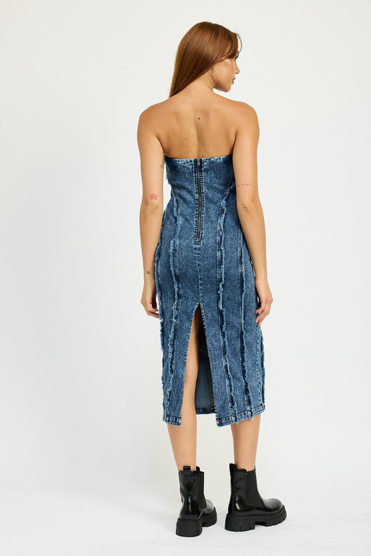 A person wearing the TUBE FRAYED SEAM MIDI DRESS, a strapless, form-fitting denim dress with frayed edges, and imported black ankle boots poses against a plain white background.