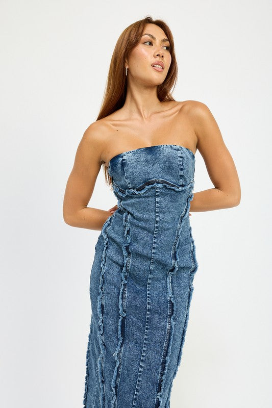 A person wearing the TUBE FRAYED SEAM MIDI DRESS, a strapless, form-fitting denim dress with frayed edges, and imported black ankle boots poses against a plain white background.