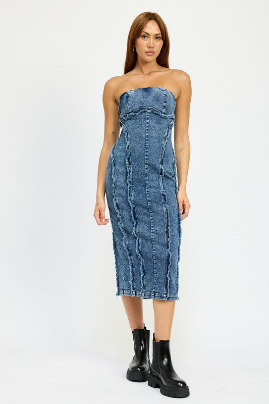 A person wearing the TUBE FRAYED SEAM MIDI DRESS, a strapless, form-fitting denim dress with frayed edges, and imported black ankle boots poses against a plain white background.