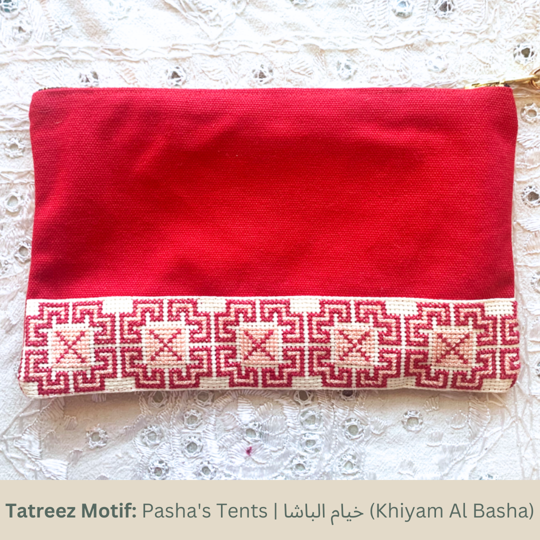 The Safa Tatreez Pouch - Red showcases exquisite Palestinian tatreez with intricate geometric patterns along the bottom edge. Hand-embroidered with care, it supports fair trade practices.