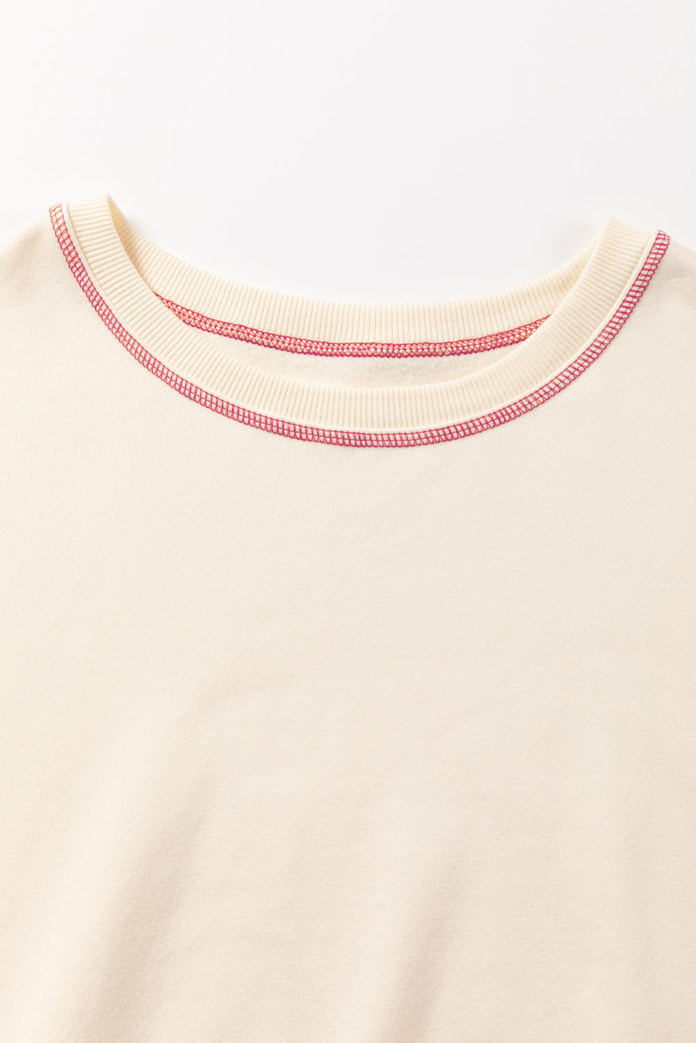 A woman with blonde hair is facing away, wearing a Contrast Stitching Split Baggy Sweatshirt. She stands in a room adorned with plants and wooden furniture in the background.