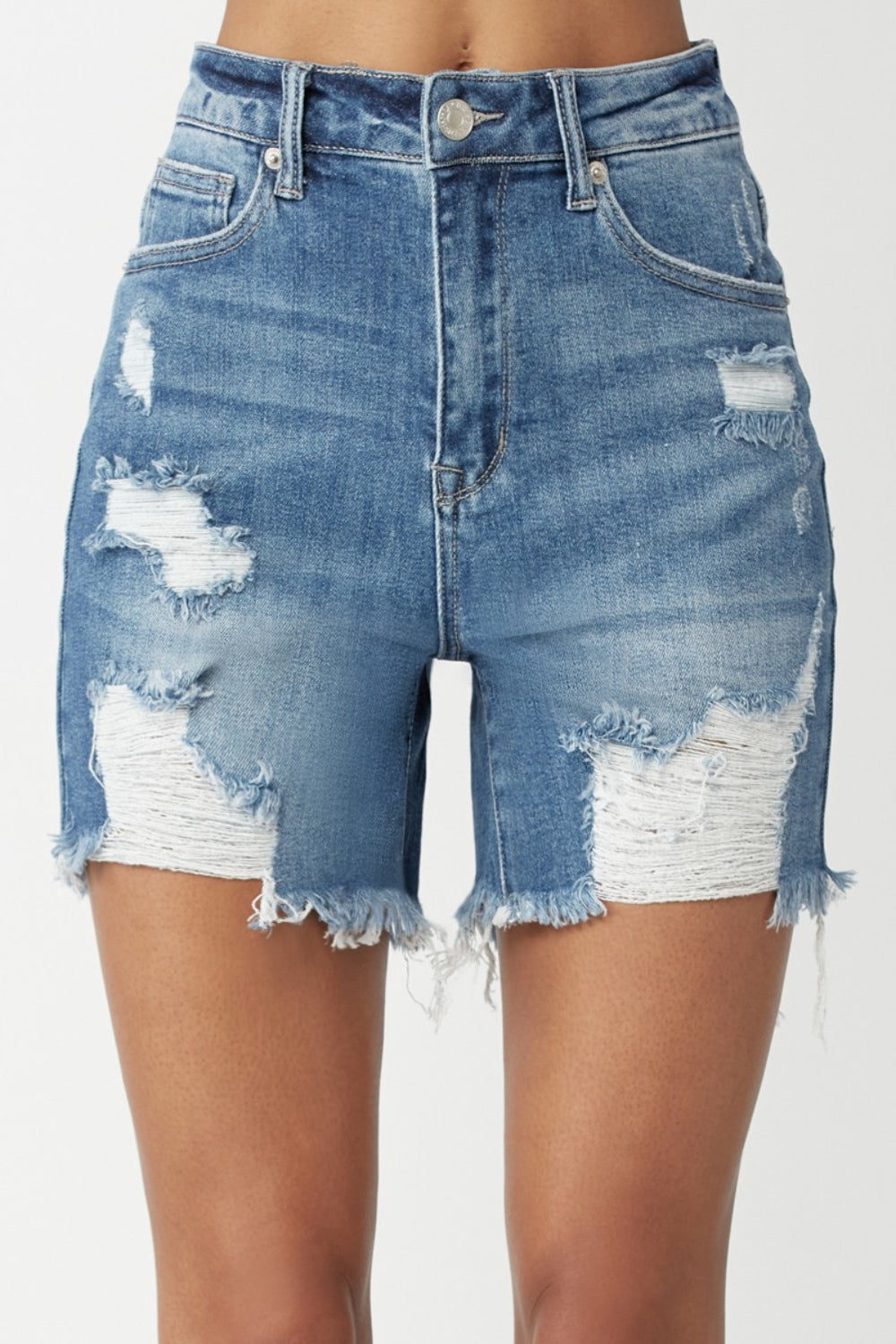 A person wearing RISEN High Waisted Distressed Denim Shorts with frayed detailing and a faded wash. This summer essential embodies an edgy style perfect for warm days.