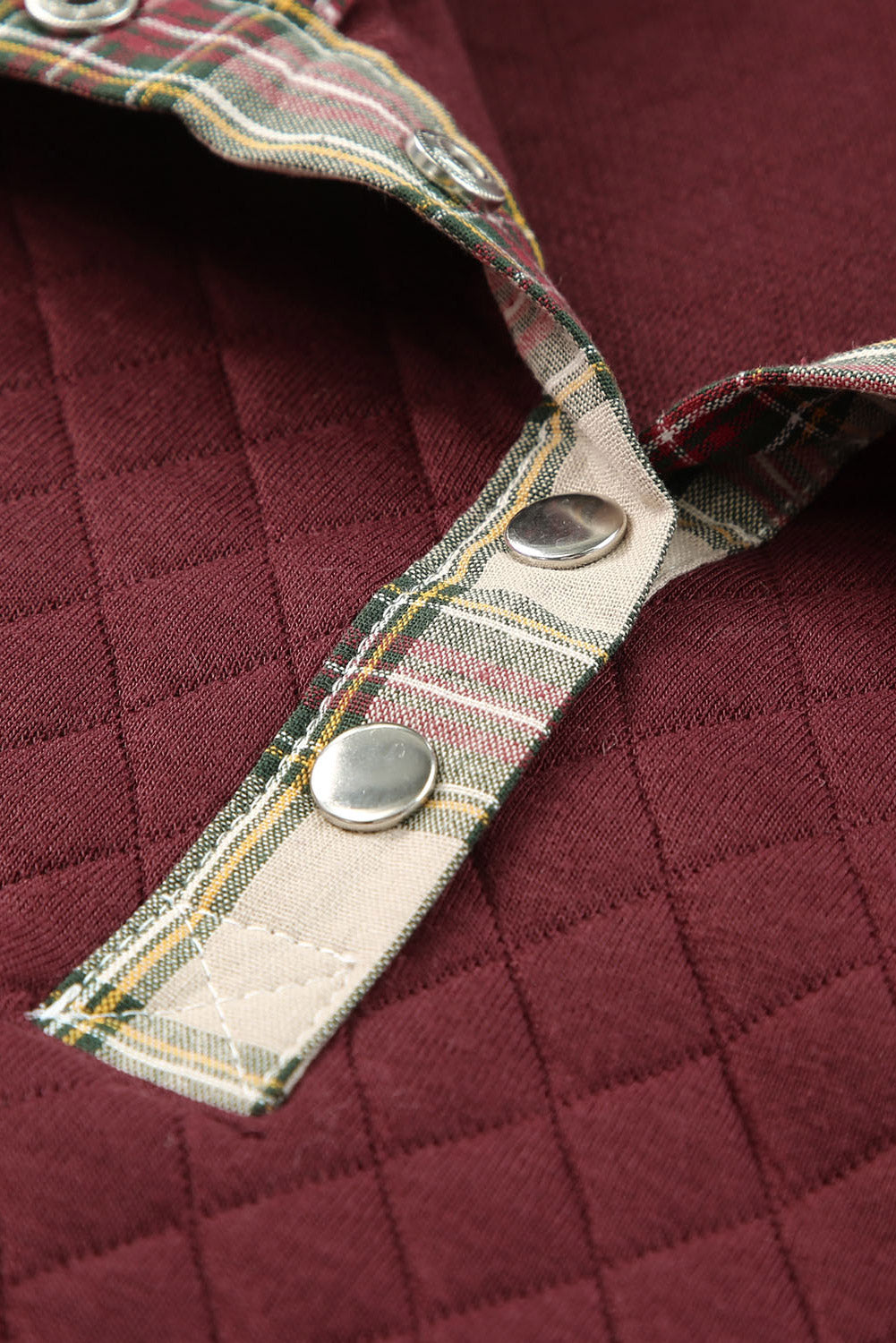 A person with wavy hair is wearing a chic Fiery Red Geometric Texture Plaid Trim Sweatshirt. They have a brown crossbody bag and are facing away from the camera, with a gray textured wall in the background.