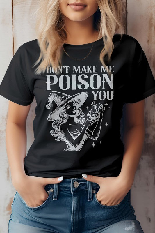 A woman is wearing the "Don't Make Me Poison You Graphic Tee," which showcases a witch with her magic potion and the phrase "Don't Make Me Poison You." Crafted from eco-friendly materials, this T-shirt effortlessly combines style and sustainability.