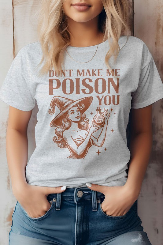 A woman is wearing the "Don't Make Me Poison You Graphic Tee," which showcases a witch with her magic potion and the phrase "Don't Make Me Poison You." Crafted from eco-friendly materials, this T-shirt effortlessly combines style and sustainability.