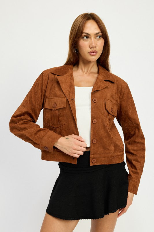 A woman with long hair wears a SUDE JACKET WITH POCKETS in brown polyester over a white top and a black skirt, size small, posing against a white background.