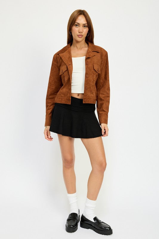 A woman with long hair wears a SUDE JACKET WITH POCKETS in brown polyester over a white top and a black skirt, size small, posing against a white background.