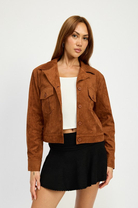 A woman with long hair wears a SUDE JACKET WITH POCKETS in brown polyester over a white top and a black skirt, size small, posing against a white background.