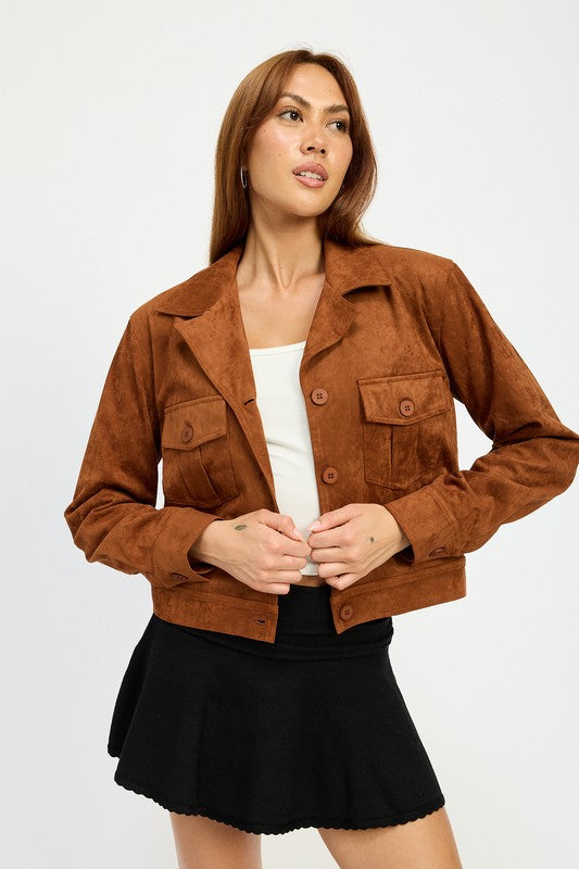 A woman with long hair wears a SUDE JACKET WITH POCKETS in brown polyester over a white top and a black skirt, size small, posing against a white background.