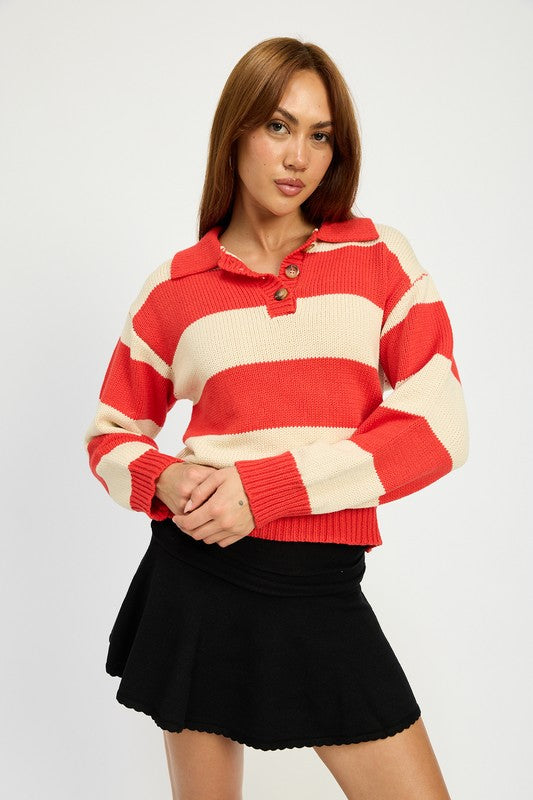 A person with long hair is wearing the STRIPED COLLARED SWEATER TOP, featuring red and white stripes with buttons, paired with a black skirt. The model wears size small, showcasing the piece’s sleek fit against a plain white background.