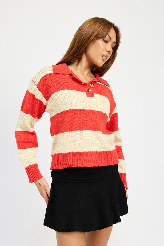 A person with long hair is wearing the STRIPED COLLARED SWEATER TOP, featuring red and white stripes with buttons, paired with a black skirt. The model wears size small, showcasing the piece’s sleek fit against a plain white background.