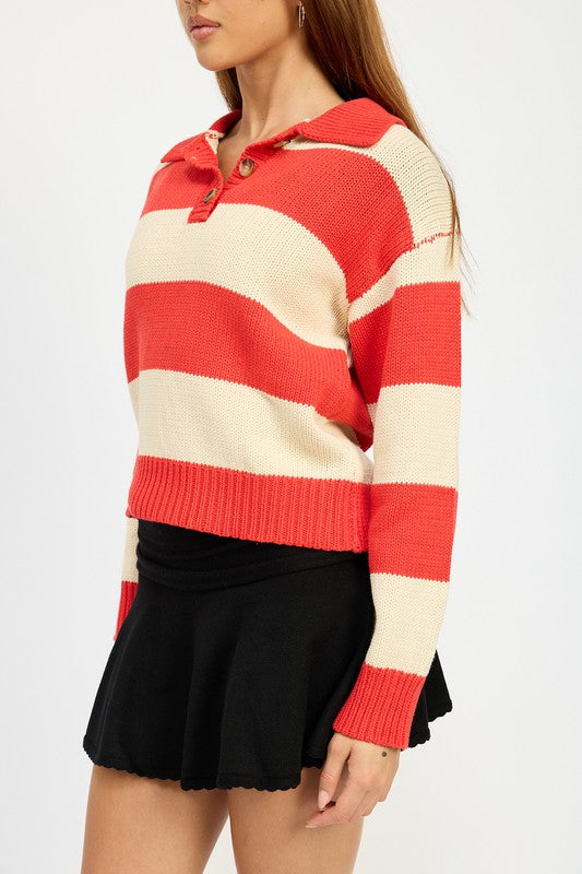 A person with long hair is wearing the STRIPED COLLARED SWEATER TOP, featuring red and white stripes with buttons, paired with a black skirt. The model wears size small, showcasing the piece’s sleek fit against a plain white background.